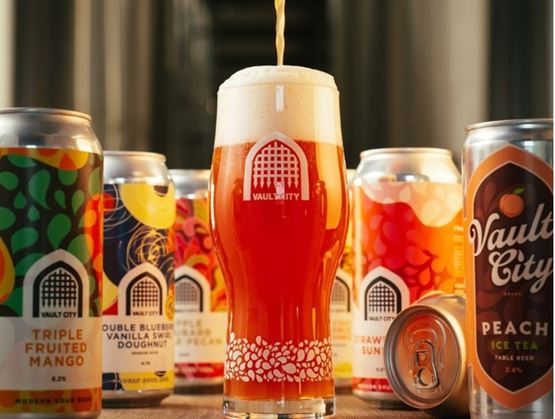 Glass of beer with cans of beer