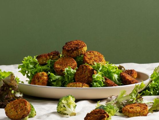 Falafels on salad on a plate with green background