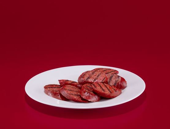 Pieces of grilled meat on a plate.