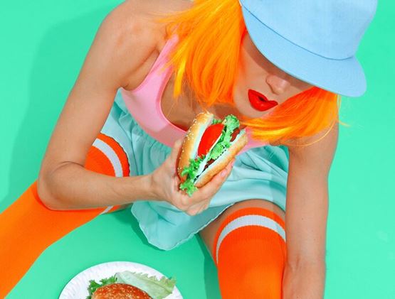 Fashion sporty playful girl with burgers. Minimal creative fast food concept art