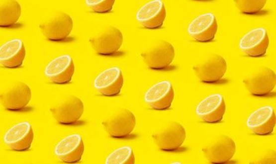 Pattern of whole and halved lemons arranged in rows on a yellow background.