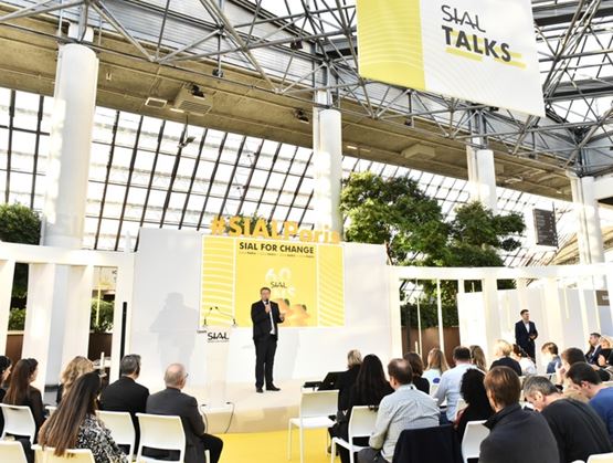 Conférence SIAL Talks avec un intervenant sur scène devant un écran « SIAL For Change », face à un public assis dans un espace lumineux.