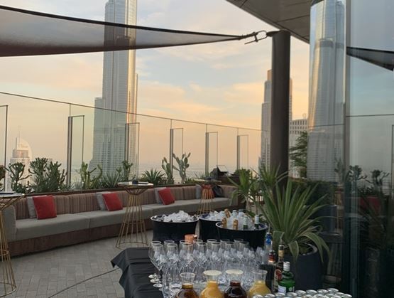 Rooftop cocktail in Dubai, with a view of the Burj Khalifa at sunset.