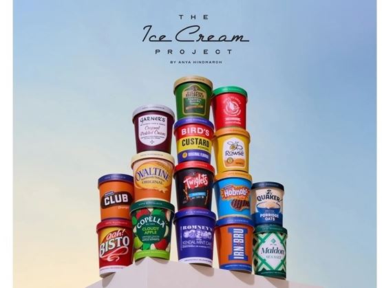 Promotional poster titled “The Ice Cream Project” featuring a pyramid of brightly colored stacked ice cream tubs inspired by iconic brands and products, set against a soft pastel blue gradient background.