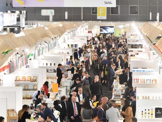 Allée animée d’un salon professionnel avec de nombreux exposants et visiteurs sous un panneau indiquant « Savory Food – Épicerie salée » dans le Hall 1.