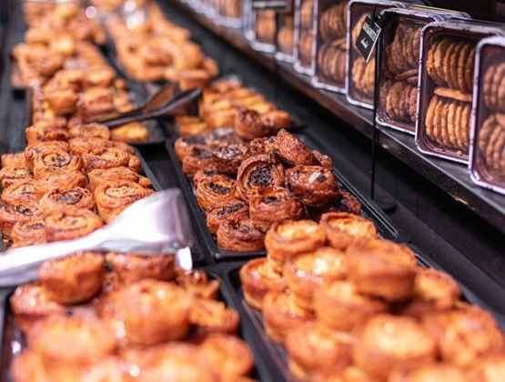 Assortiment de viennoiseries et de biscuits présentés dans une boulangerie.