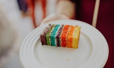 Voici une part de gâteau arc-en-ciel aux couleurs vives. Il a l'air délicieux !