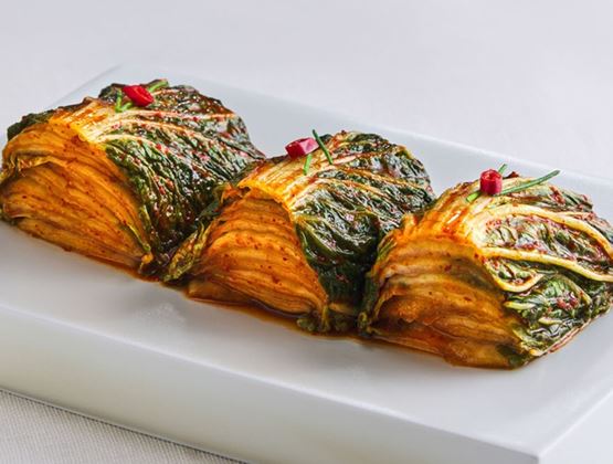 Portions of cabbage kimchi served on a white plate.