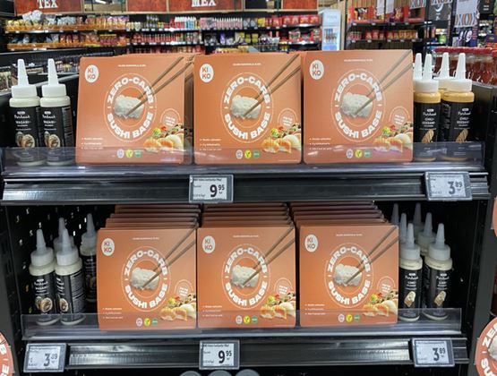 Display of Kikko zero-carb sushi bazooka kits, surrounded by sushi sauces on supermarket shelves.