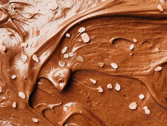 Gros plan sur une crème au chocolat onctueuse parsemée de cristaux de gros sel.