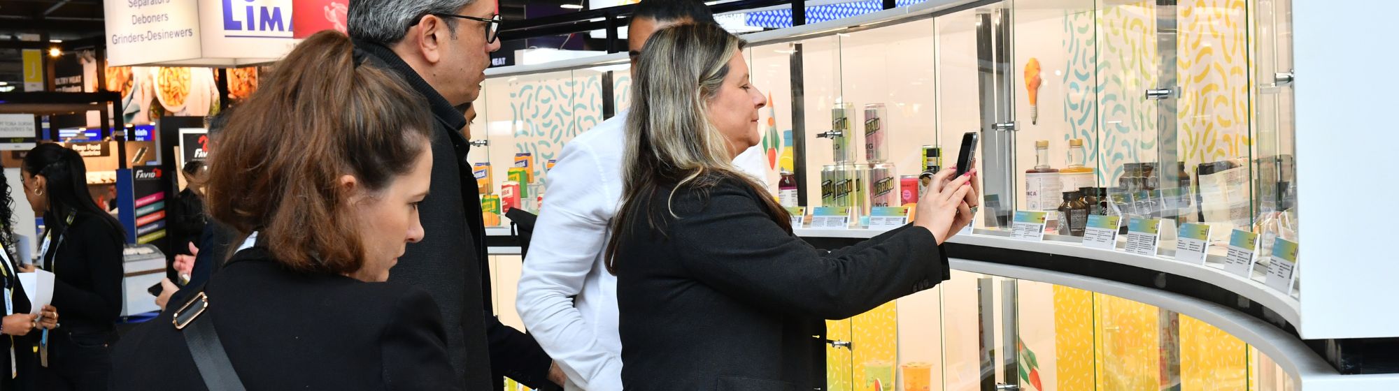 Visitors at SIAL Paris examining innovative products showcased in the SIAL Innovation display cases.