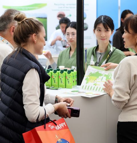 Personnes échangeant sur un stand lors d’un salon professionnel, présentation de produits et discussion commerciale