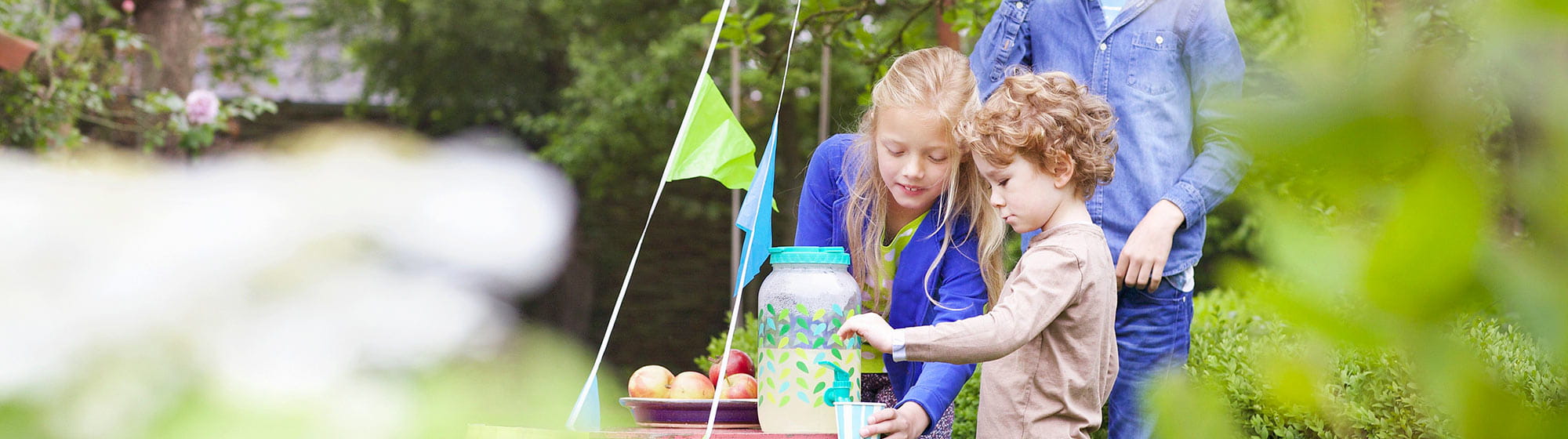 Kids drinking lemonade in a garden 