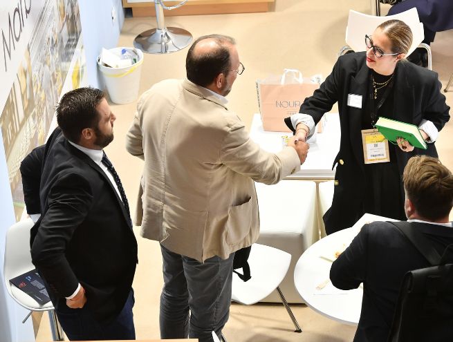 Business meeting between professionals shaking hands at a trade show.