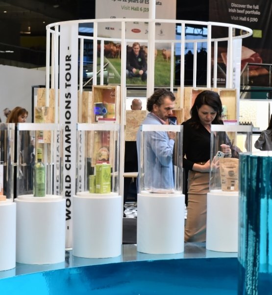 Visitors looking at products displayed in a World Champions Tour area at a trade show.