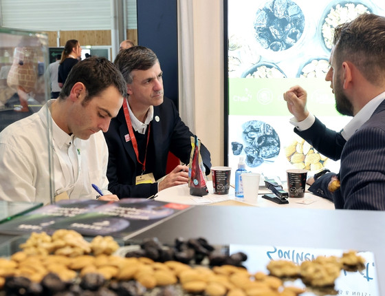 Meeting at a food industry booth with dried fruit tasting and product presentation.