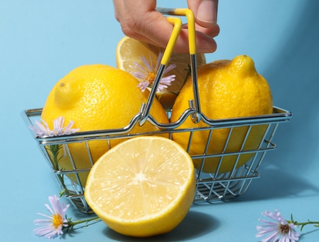 Une main portant un panier plein de citrons