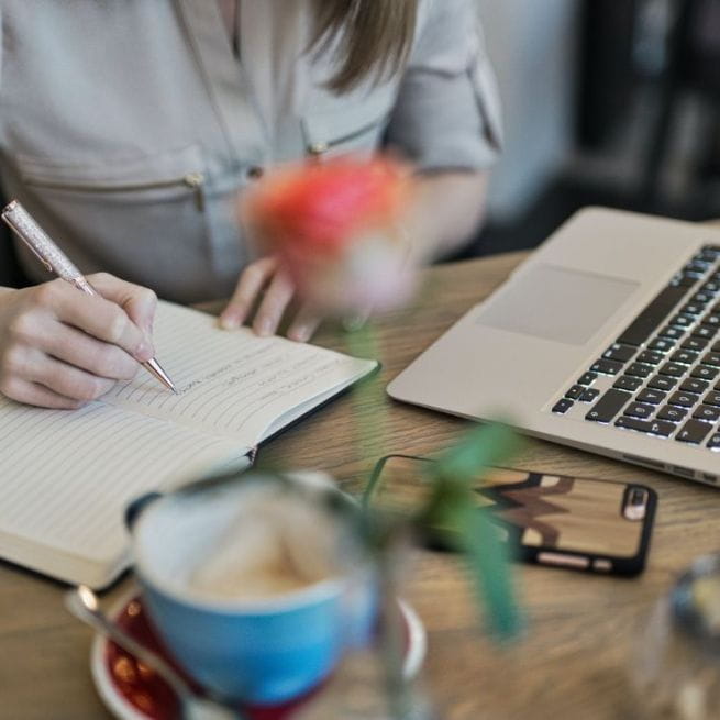 Femme avec un ordinateur portable et un cahier