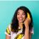 Smiling woman wearing a yellow top against a plain yellow background.