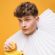 Jeune homme portant une veste jaune sur fond jaune.