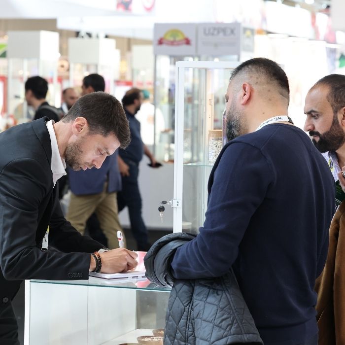Professionnels echangeant sur un stand lors du salon SIAL Paris.
