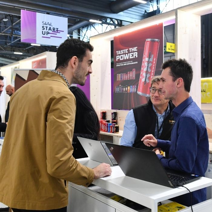 Professionals discussing at a booth during SIAL Paris trade show.