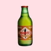 Green glass bottle of Pimento drink, on a pale pink background