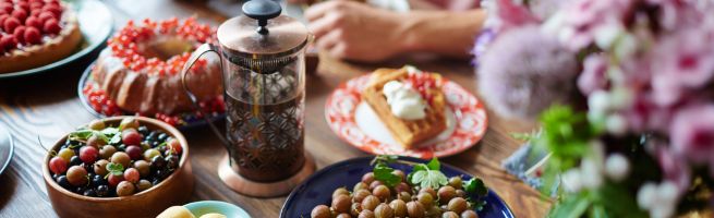 Organic products (coffee, waffles, cake, fruit) on a table