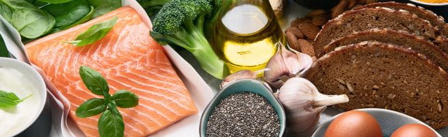 Produits bio (saumon, pain, huile d'olive, poivre) sur une table
