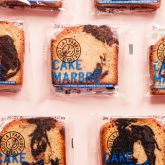 Individually wrapped marble cake slices from La Fabrique du Cookie arranged in a repetitive pattern.