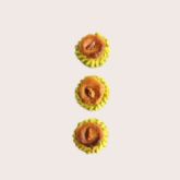 Three golden oriental pastries aligned vertically on a light background.