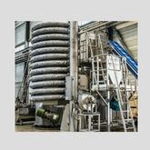 Machine industrielle avec des tuyaux en spirale empilés et des escaliers d'accès
