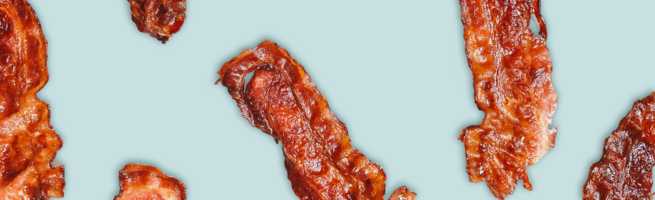 Grilled bacon strips arranged in a graphic pattern on a light blue background