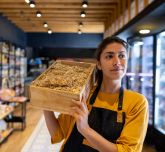Une femme qui porte une palette avec du saucisson dedans
