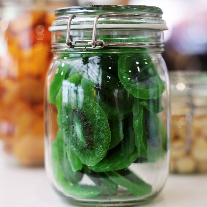 Glass jar filled with dried kiwi slices.