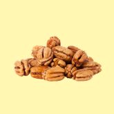 Whole pecan nuts on a yellow background.