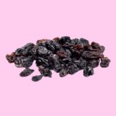 Raisins secs noirs sur fond rose.