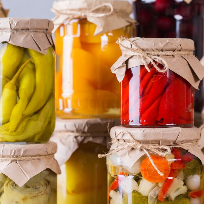Bocaux de légumes marinés et conserves colorées empilés.