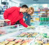 Un couple dans un magasin au rayon des surgelés 