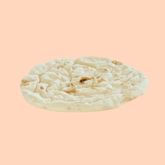 Flat pizza dough with an irregular texture, on a pink background