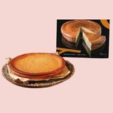 Cheese tart displayed on a plate with a tart box in the background, on a pink background