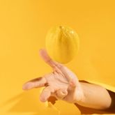 yellow lemon floating in the air with a bright yellow background.