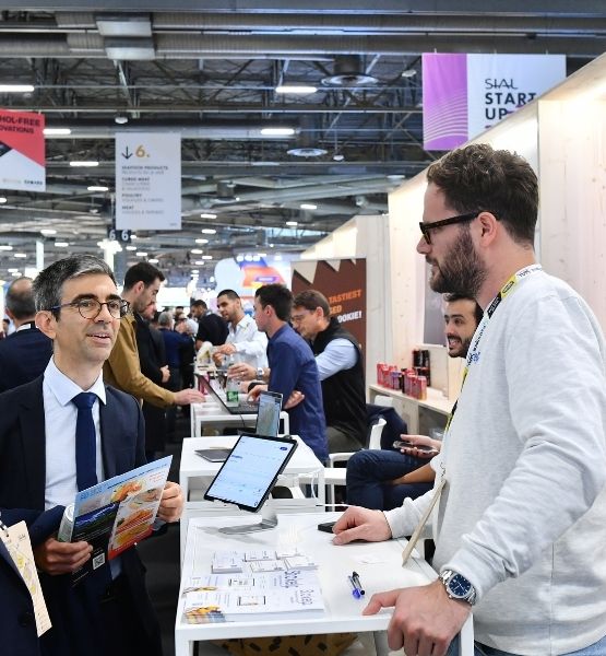 Meeting between two people at a booth in the SIAL Start-up Village in Paris.