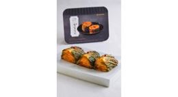 Sliced kimchi arranged on a white plate, with elegant packaging in the background.