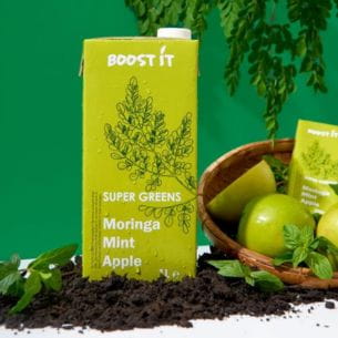 Super Greens drink made with moringa, mint, and apple, in green packaging, with apples and mint leaves.