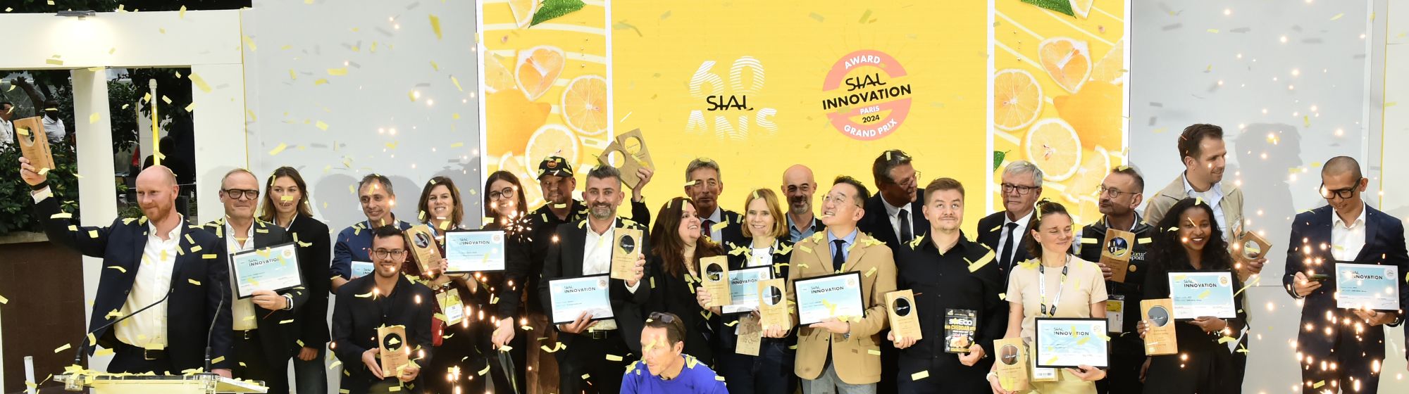 Winners of the SIAL Innovation Awards 2024 posing on stage with their trophies, surrounded by confetti.