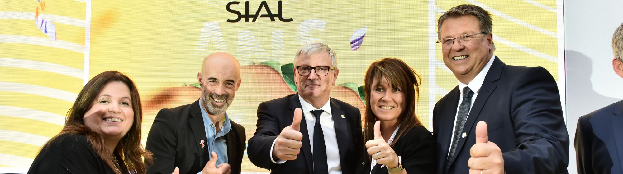 Team celebrating SIAL Paris's 60th anniversary with thumbs up in front of the SIAL Innovation logo.