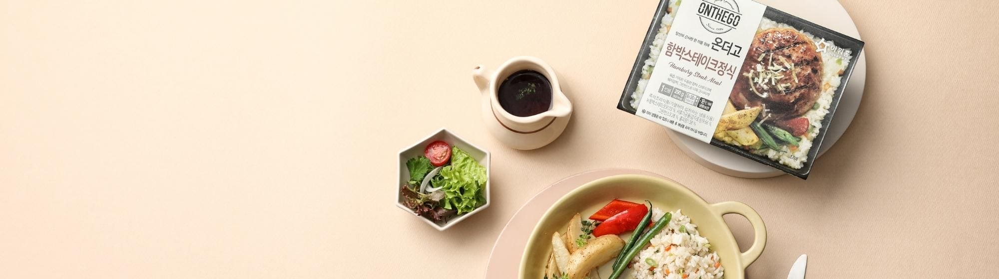 Plat de repas avec riz, légumes, et viande, accompagné de sauce dans un fond beige.