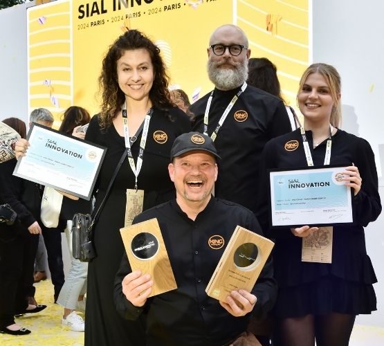 King Konjac team posing with SIAL Innovation certificates and trophies in front of a yellow backdrop.