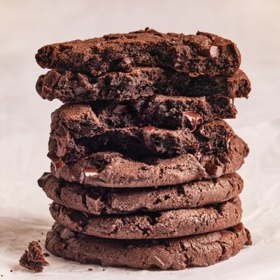 Stack of soft dark chocolate cookies on a light background.